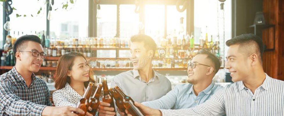 group-happy-asian-men-women-gathering-together-modern-sunny-bar-toasting-beer-bottles-cheerful-ethnic-people-123903101